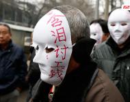 近幾年，由于經(jīng)濟增速下行，中西部地區(qū)和中小城市成為當(dāng)前討薪矛盾多發(fā)地區(qū)。一邊是國家和地方維護打工者權(quán)益的法律法規(guī)不斷出臺，另一邊則是“年年干活年年欠，年年討薪年年難”。不少打工者不得已只好采取行為藝術(shù)等手段以博取關(guān)注。圖為2015年2月2日，西安市尚德路陜西省水利廳的門前，七八位頭戴著白色面具者站在凜凜寒風(fēng)中，面具上寫著：“含淚討工錢” “無顏見父母”等標(biāo)語。據(jù)了解，這幾個人是70名農(nóng)民工的代表，他們之前在武功縣干的工程被欠款156萬元。誰知，包工頭不但電話打不通，以前的家也搬了，根本找不到人，多次找到水